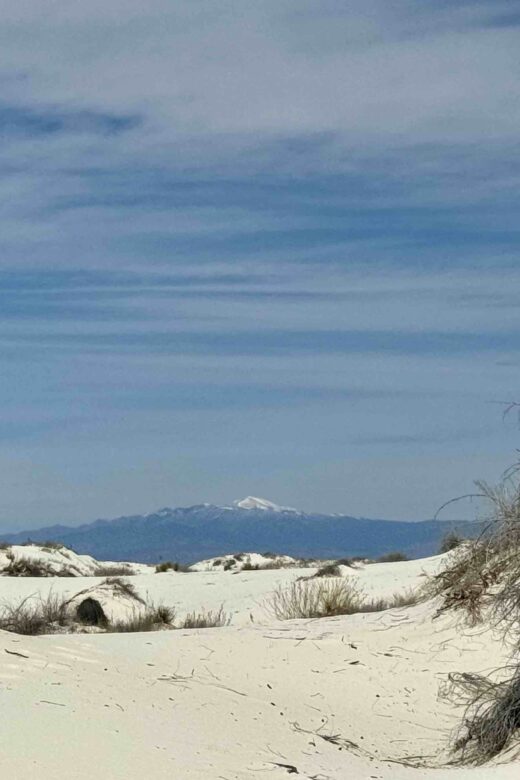 white sands and blue sky with mountain i